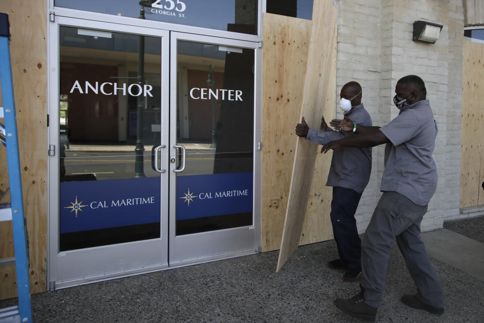 Workers board up a window front on Georgia Street on Wednesday, June 3, 2020, in Vallejo, Calif. (AP Photo/Ben Margot)