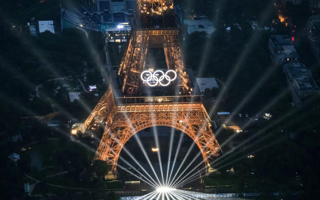 A photograph taken from an helicopter on July 26, 2024 shows an aerial view of the Eiffel Tower and the Olympics Rings lightened up during the opening ceremony of the Paris 2024 Olympic Games in Paris