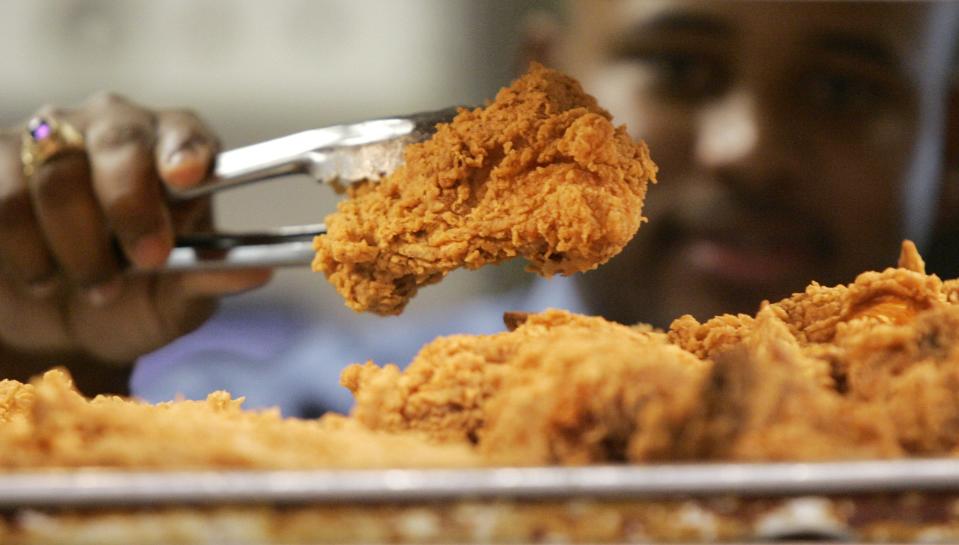 In this Monday, Oct. 30, 2006 photo, a Kentucky Fried Chicken employee uses tongs to hold up an sample of the company's trans fat-free Extra Crispy fried chicken in New York.