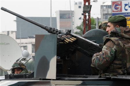 Lebanese army soldiers are seen on their military vehicle as they deployed on the streets of Tripoli, northern Lebanon, December 3, 2013. REUTERS/Stringer