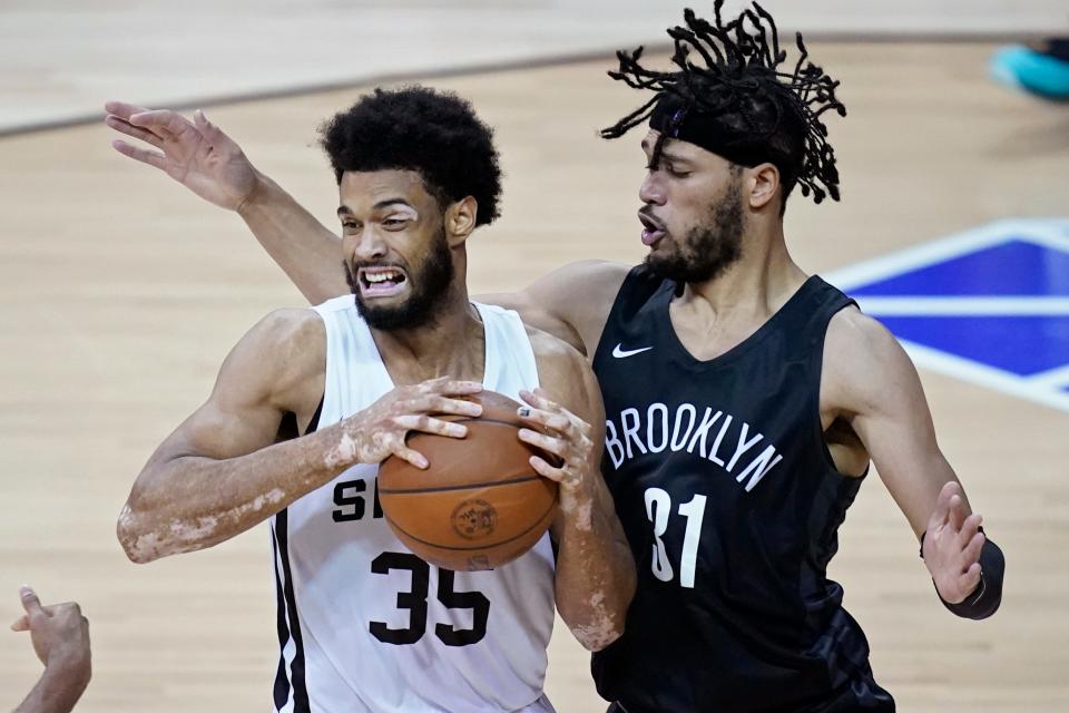 San Antonio Spurs' Nate Renfro drives into Brooklyn Nets' Kaiser Gates during the second half of an NBA summer league basketball game Sunday, Aug. 15, 2021, in Las Vegas. (AP Photo/John Locher)