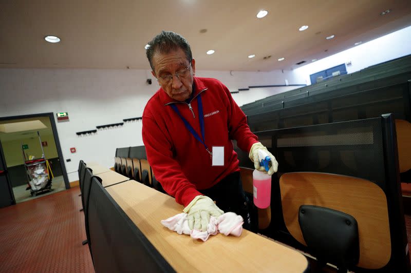 Man cleans an empty class room at the Bicocca University in Milan