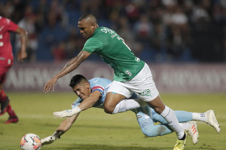 Angelo Rodriguez of Colombia's Deportivo Cali fight for the ball with goalkeeper Pablo Gavilan of Paraguay's River Plateduring a Copa Sudamericana soccer game in Asuncion, Paraguay, Tuesday, Feb. 25, 2020. (AP Photo/Jorge Saenz)