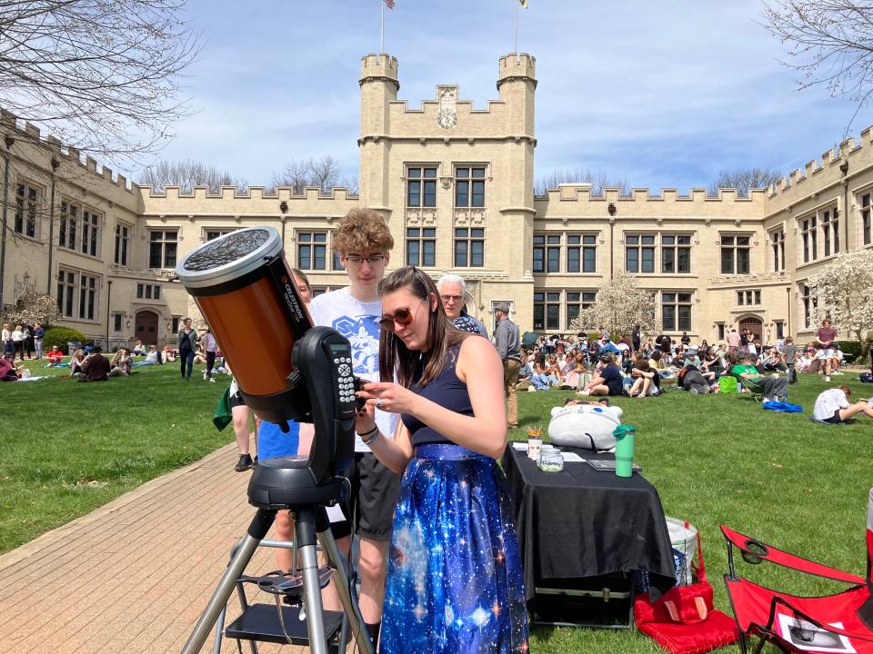 Megan Nieberding, a visiting physics professor at the College of Wooster, adjusted her high-powered telescope, as a student waited for an up-close view of the eclipse during an event on the college’s south quad Monday.