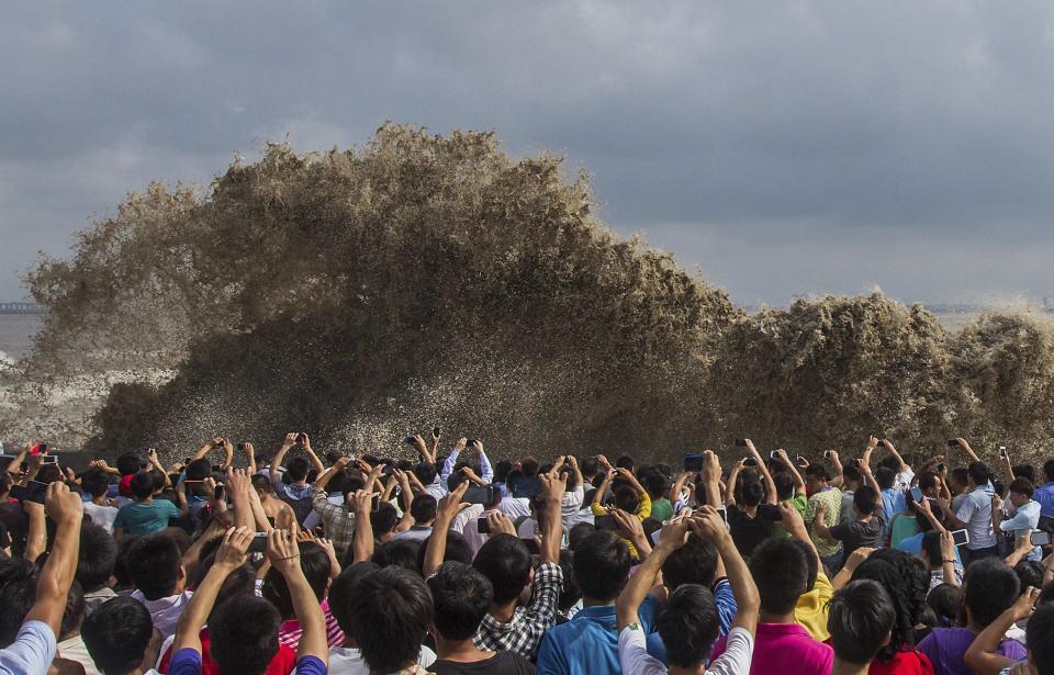 Visitors take pictures of tidal waves under the influence of Typhoon Usagi in Hangzhou, Zhejiang province, September 22, 2013. According to official Xinhua news agency, China's National Meteorological Center issued its highest alert, warning that Usagi would bring gales and downpours to southern coastal areas. REUTERS/Chance Chan (CHINA - Tags: ENVIRONMENT SOCIETY DISASTER TPX IMAGES OF THE DAY) CHINA OUT. NO COMMERCIAL OR EDITORIAL SALES IN CHINA