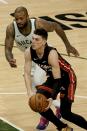 Miami Heat's Tyler Herro drives past Milwaukee Bucks' P.J. Tucker during the first half of an NBA basketball game Saturday, May 15, 2021, in Milwaukee. (AP Photo/Morry Gash)