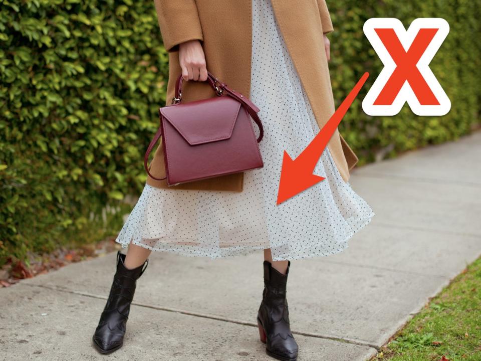 red x over woman wearing a white midi skirt and a camel coat and holding a red bag