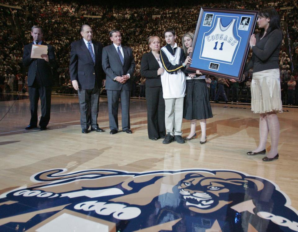 The Cosic family holds up a framed jersey of Kresimir Cosic during a retirement ceremony at the Marriott Center in Provo on Saturday, March 4, 2006. | Jason Olson, Deseret News