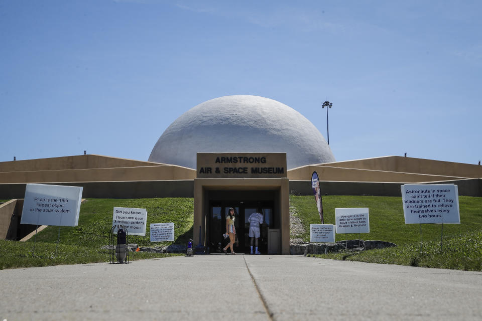 Visitors linger outside the Armstrong Air & Space Museum, Wednesday, June 26, 2019, in Wapakoneta, Ohio. Neil Armstrong helped put Wapakoneta on the map July 20, 1969, when he became the first human to walk on the moon. The late astronaut remains larger than life in the city 60 miles (96.56 kilometers) north of Dayton, where visitors are greeted by the space base-shaped top of the space museum named for him as they exit Interstate 75. (AP Photo/John Minchillo)