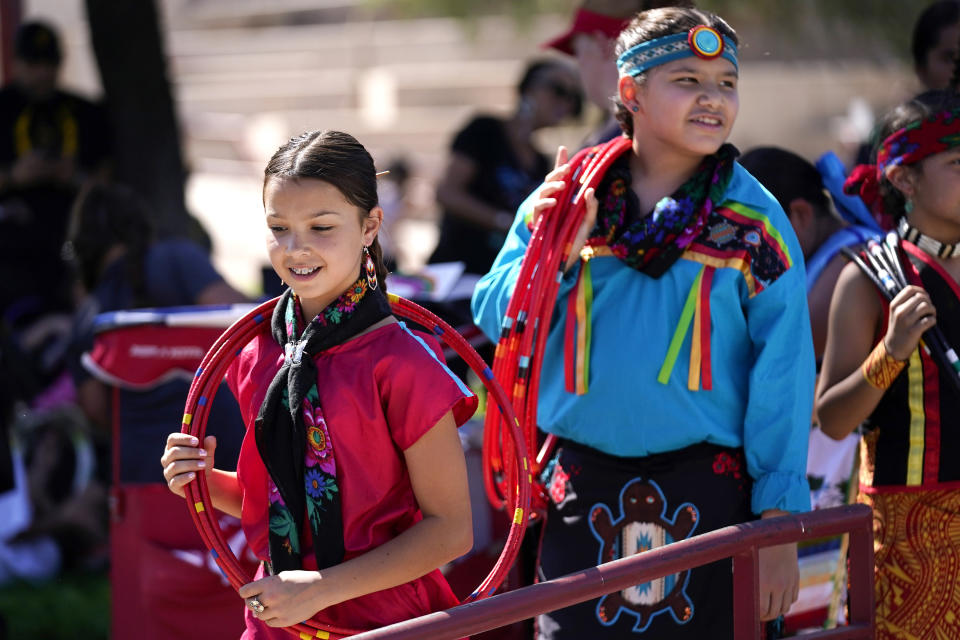 Performers from the Native American Hoop Dance of Ballet Arizona smile as they walk to the stage prior to dancing at an Indigenous Peoples Day festival Monday, Oct. 9, 2023, in Phoenix. (AP Photo/Ross D. Franklin)