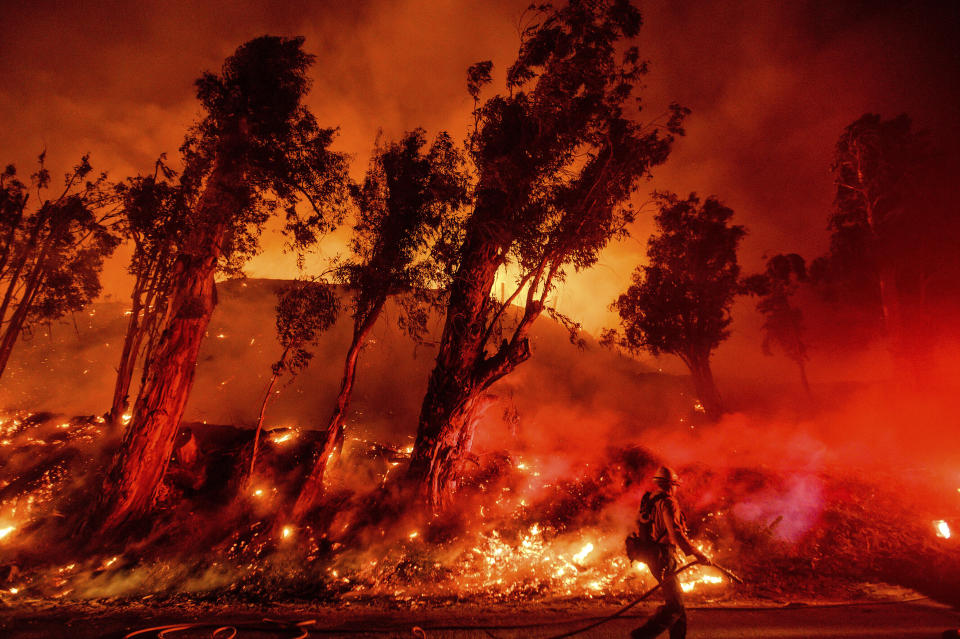 FILE - This Nov. 1, 2019, file photo shows flames from a backfire on a hillside as firefighters battle the Maria Fire in Santa Paula, Calif. California Gov. Gavin Newsom is urging a federal judge to reject Pacific Gas and Electric's blueprint for getting out of bankruptcy and renewing his threat to lead a bid to turn the beleaguered utility into a government-run operation. PG&E is trying to dig out of a financial hole created by more than $50 billion in claims stemming from a series of catastrophic wildfires that have been blamed on the San Francisco company. (AP Photo/Noah Berger, File)