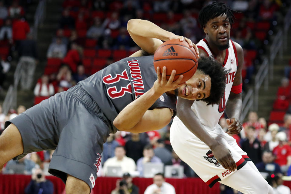 Louisville's Jordan Nwora (33) tries to stay in bounds after battling for the ball with North Carolina State's DJ Funderburk (0) during the second half of an NCAA college basketball game in Raleigh, N.C., Saturday, Feb. 1, 2020. (AP Photo/Karl B DeBlaker)