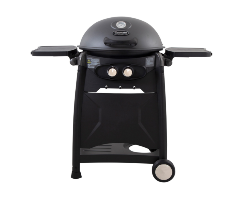 A black stand alone two burner bbq with the lid on and two serving trays on either side against a white background.