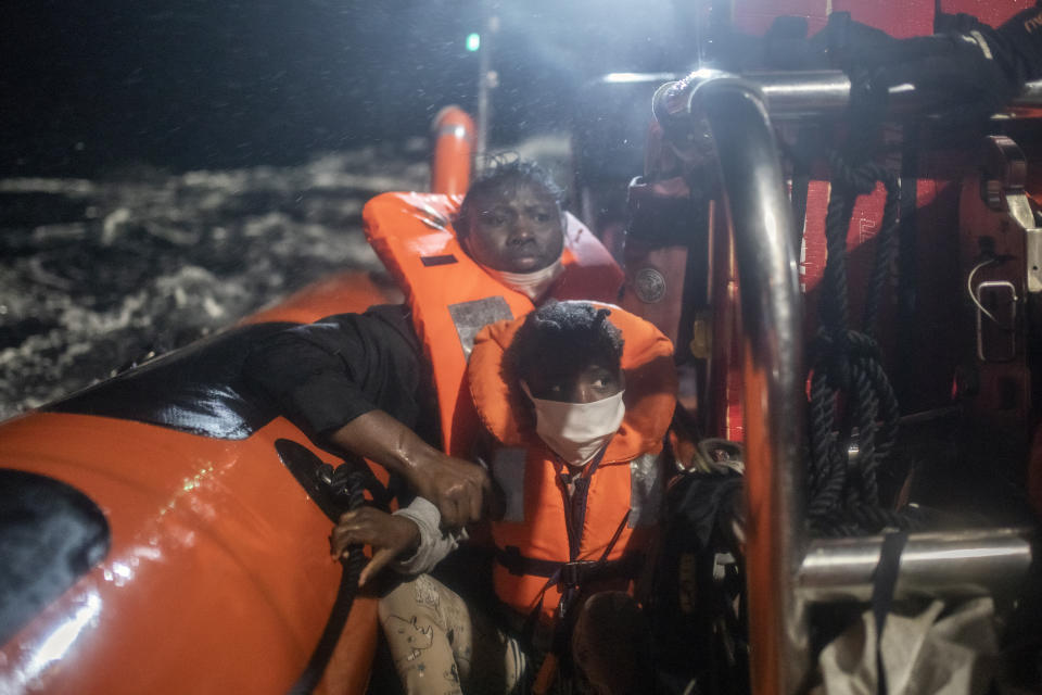 25-year-old Santa, originally from the Ivory Coast clutches her 5-year-old daughter Timi's arm to prevent her from falling into the water, after being rescued by the Spanish NGO Open Arms rescue vessel in the Mediterranean Sea, international waters, Saturday, Feb. 13, 2021. Various African migrants drifting in the Mediterranean Sea after fleeing Libya on unseaworthy boats have been rescued. In recent days, the Libyans had already thwarted eight rescue attempts by the Open Arms, a Spanish NGO vessel, harassing and threatening its crew in international waters. (AP Photo/Bruno Thevenin)