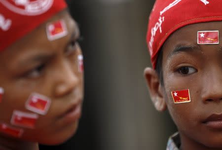 Children wear National League for Democracy (NLD) party flag stickers on their faces while waiting for Myanmar pro-democracy leader Aung San Suu Kyi during her campaign in her constituency of Kawhmu township outside Yangon September 21, 2015. REUTERS/Soe Zeya Tun