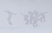 Snowboarders compete though a fog during the men's snowboard cross finals at the 2014 Sochi Winter Olympic Games in Rosa Khutor, in this February 18, 2014 file photo. REUTERS/Mike Segar/Files (RUSSIA - Tags: SPORT OLYMPICS SPORT SNOWBOARDING TPX IMAGES OF THE DAY ENVIRONMENT)