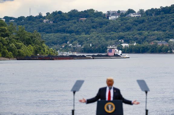 A coal barge is positioned as a backdrop behind President Donald Trump as he speaks during a rally at the Rivertowne Marina, in Cincinnati on June 7, 2017.