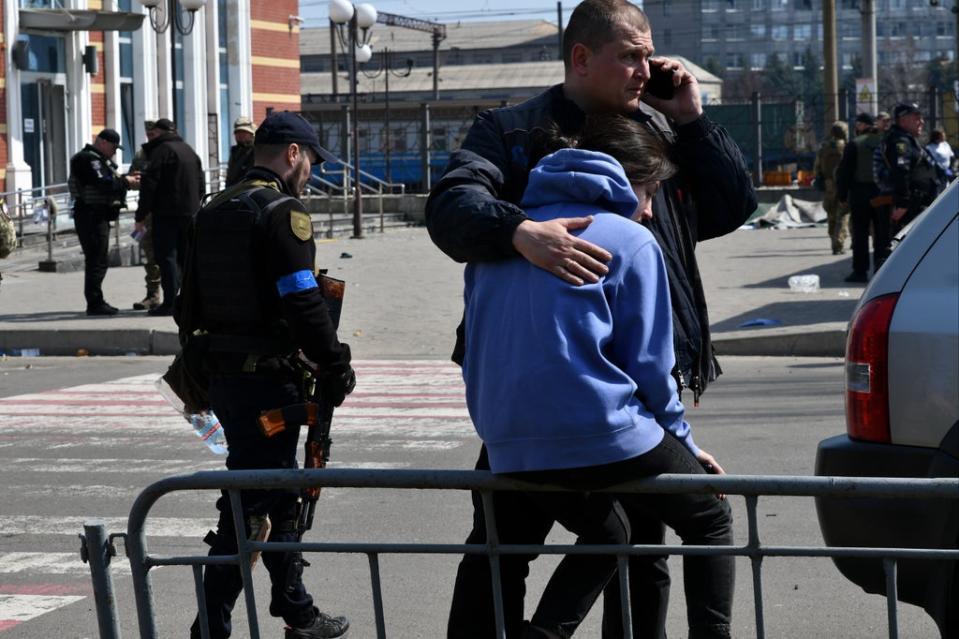 A man hugs a woman after Russian shelling at the railway station in Kramatorsk, (AP)