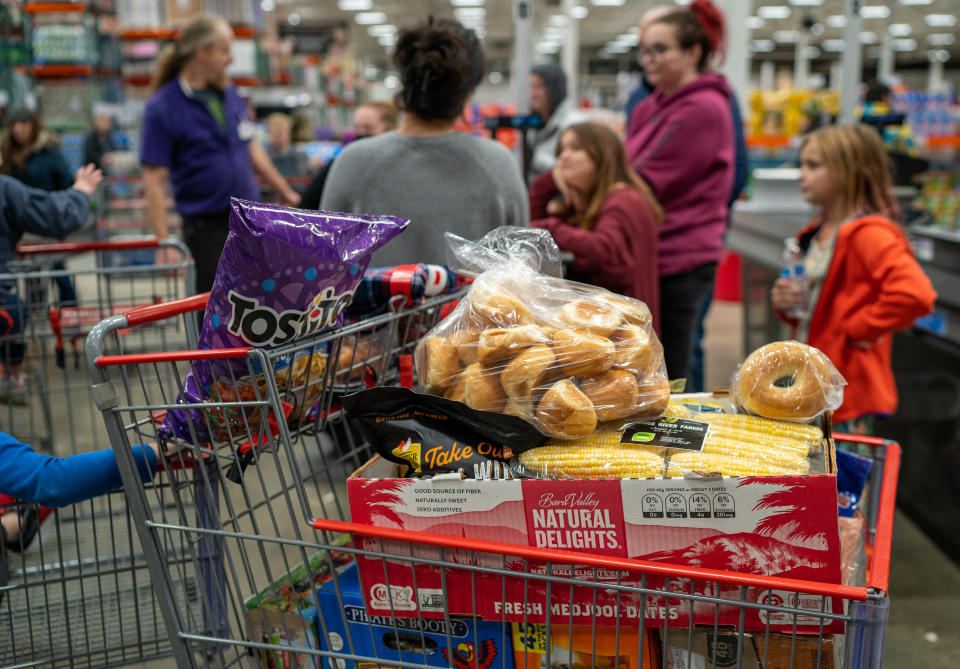 COLCHESTER, VERMONT - NOVEMBER 13: A family moves through the checkout line with groceries at a Costco grocery store November 13, 2023 in Colchester, Vermont.  (Photo by Robert Nickelsberg/Getty Images)