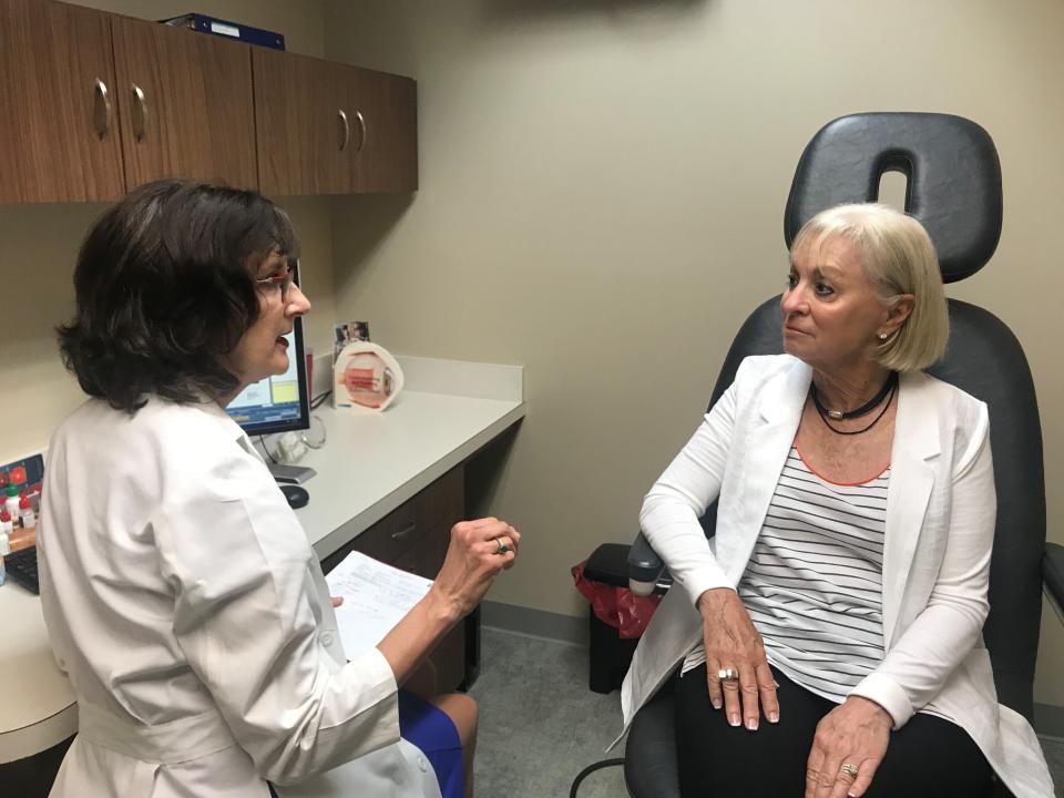 FILE - In this July 17, 2019, file photo, Laurie Barber, a Little Rock, Ark., ophthalmologist, talks with patient Carolyn Lay at the Little Rock Eye Clinic. Barber chairs a group that wants to hold a referendum on a new Arkansas law that expands the procedures that optometrists can perform. Arkansas election officials on Friday, Aug. 2, 2019, rejected the attempt to hold a referendum next year on a new state law expanding what procedures optometrists can perform that has sparked an unusually expensive and public lobbying fight. (AP Photo/Andrew DeMillo, File)