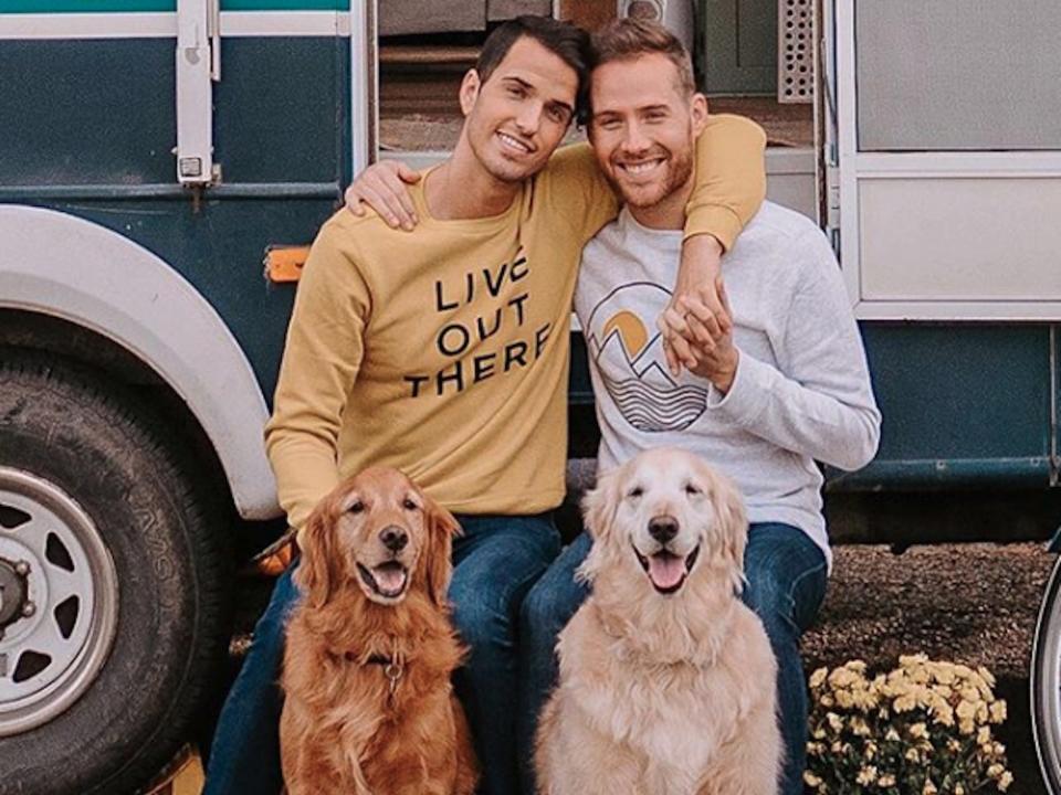 Tyler and Todd Gibbon-Thorne standing outside their RV with their two dogs