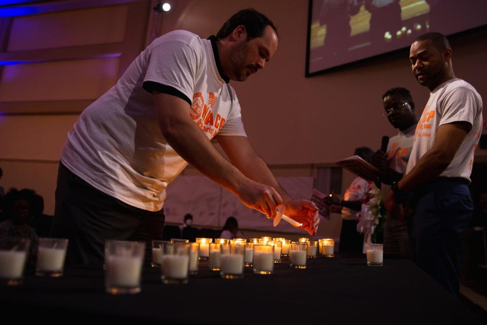A man lights a candle at Solid Rock Church during a vigil for the victims of the recent Buffalo and Uvalde shootings on Tuesday, May 31, 2022. Members of the community attended the NAACP event to mourn the lives lost and call for action.