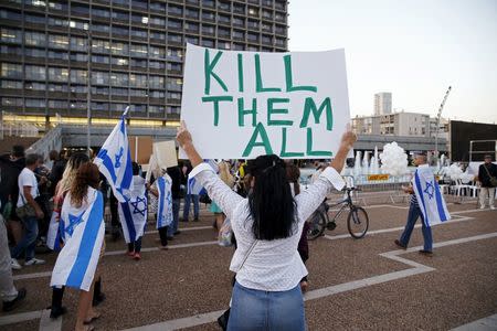 A supporter of Elor Azaria, an Israeli soldier charged with manslaughter by the Israeli military after he shot a wounded Palestinian assailant as he lay on the ground in Hebron on March 24, holds a placard during a protest calling for his release in Tel Aviv, Israel April 19, 2016. REUTERS/Baz Ratner