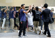 Apple Store staff share high-fives with customers who have been waiting in line to purchase Apple's new iPhone 7 and 7 Plus at the Apple Store in Tokyo's Omotesando shopping district, Japan, September 16, 2016. REUTERS/Issei Kato