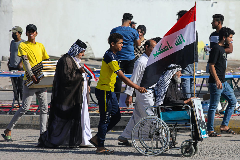 People gather for anti-government protests in Basra, Iraq, Sunday, Oct. 25, 2020. Thousands of Iraqi protesters have taken to the streets to mark one year since mass anti-government demonstrations swept Baghdad and Iraq's south. Protesters marched Sunday in the capital and several southern cities to renew demands to bring an end to corruption perpetuated by Iraq's politicians. (AP Photo/Nabil al-Jurani)