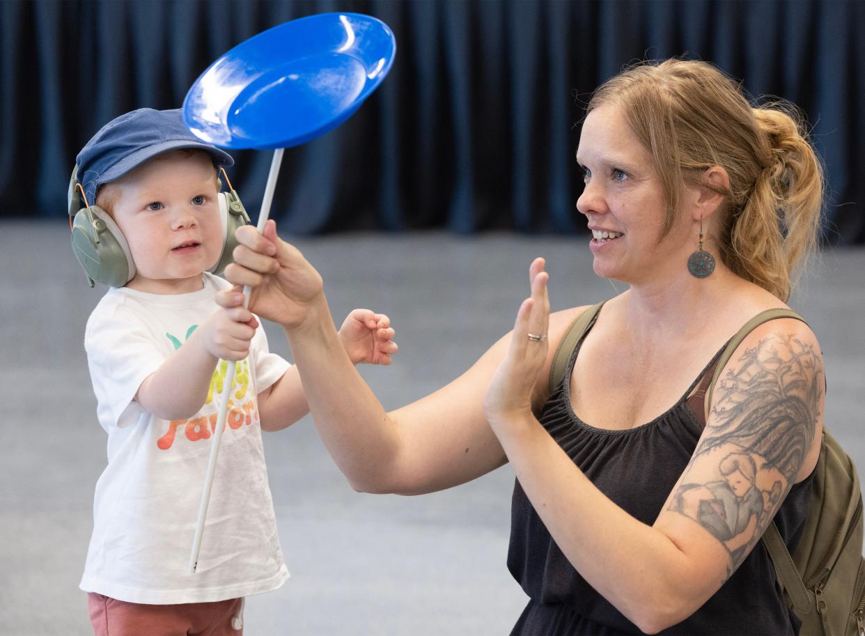 Laura McAllister and her son Edison, 3, of North Canton try their hand at spinning plates at the Downtown Massillon Fun Fest.