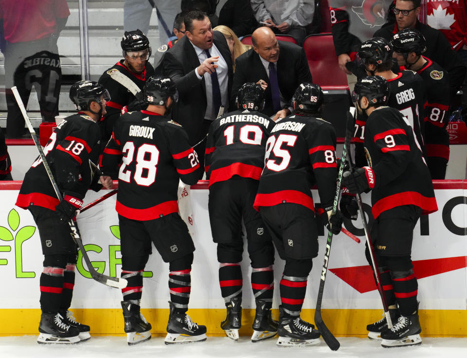 Ottawa Senators coach D.J. Smith, back left, and assistant coach Davis Payne talk to players during the third period of an NHL hockey game against the Buffalo Sabres on Tuesday, Oct. 24. 2023, in Ottawa, Ontario. (Sean Kilpatrick/The Canadian Press via AP)