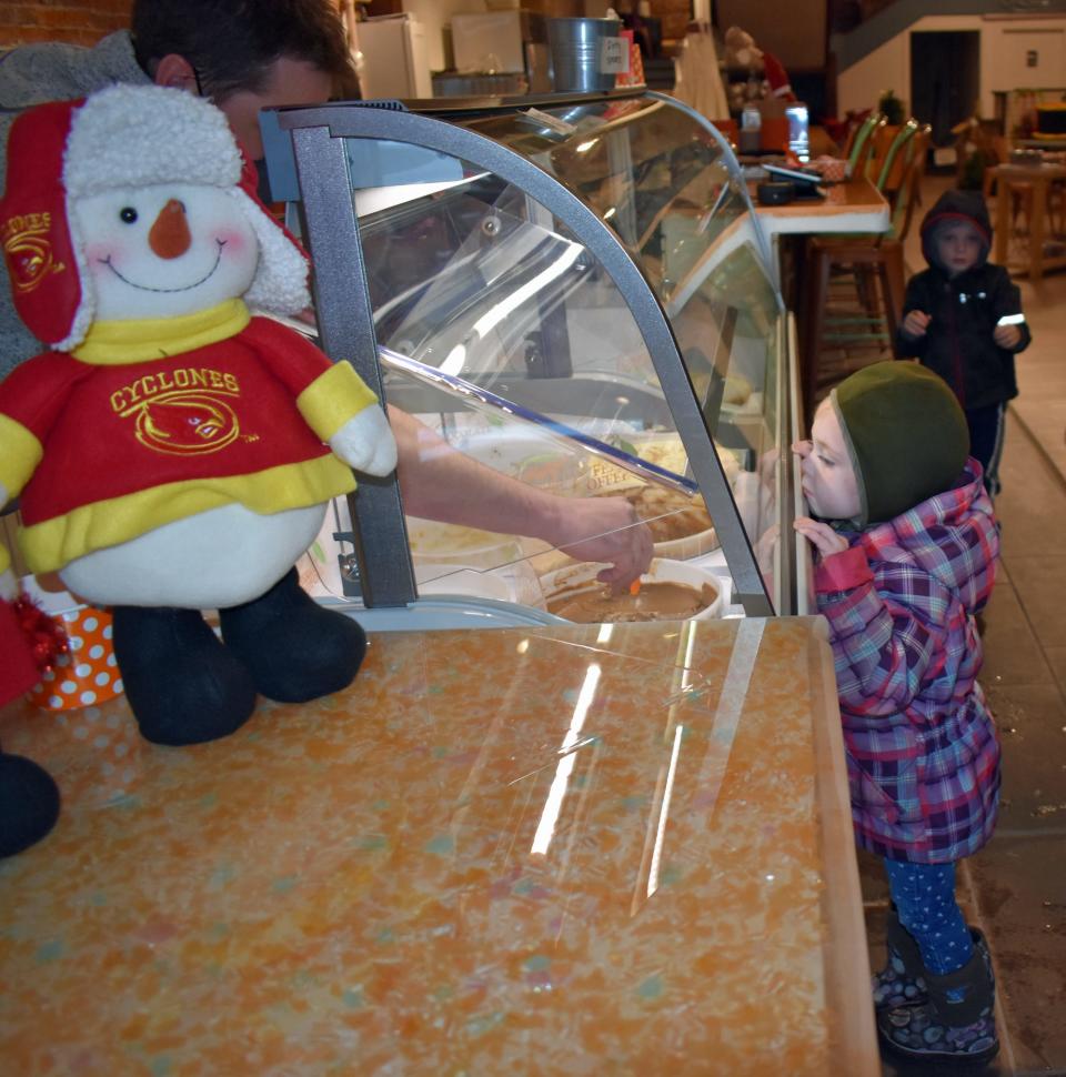 Taya Mattingly, 3, watches Marmalade Moon owner Graham Watkins scoop ice cream for her as her brother Ty, 4, waits in the background.