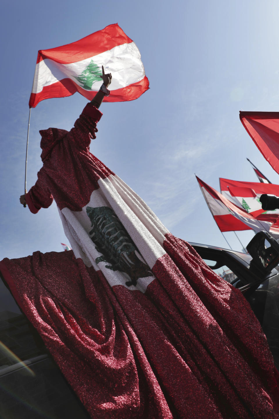 An anti-government protester wears a robe presenting the Lebanese national flag during an alternative independence celebrations at the Martyr square, in downtown Beirut, Lebanon, Friday, Nov. 22, 2019. Protesters gathered for their own alternative independence celebrations, converging by early afternoon on Martyrs' square in central Beirut, which used to be the traditional location for the official parade. Protesters have occupied the area, closing it off to traffic since mid-October. (AP Photo/Hassan Ammar)