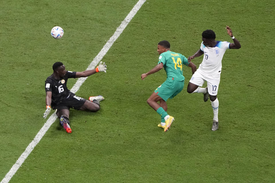 England's Bukayo Saka, right, scores his side's 3rd goal during the World Cup round of 16 soccer match between England and Senegal, at the Al Bayt Stadium in Al Khor, Qatar, Sunday, Dec. 4, 2022. (AP Photo/Ariel Schalit)