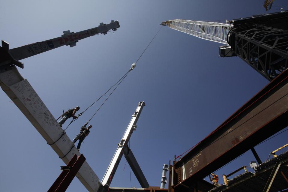 Ironworkers James Brady, left, and Billy Geoghan stand on a steel beam after connecting it to the 104th floor of 1 World Trade Center, Thursday, Aug. 2, 2012 in New York. The beam was signed by President Barack Obama with the notes: "We remember," ''We rebuild" and "We come back stronger!" during a ceremony at the construction site June 14. Since then the beam has been adorned with the autographs of workers and police officers at the site. The beam will be sealed into the structure of the tower, which is scheduled for completion in 2014. (AP Photo/Mark Lennihan)