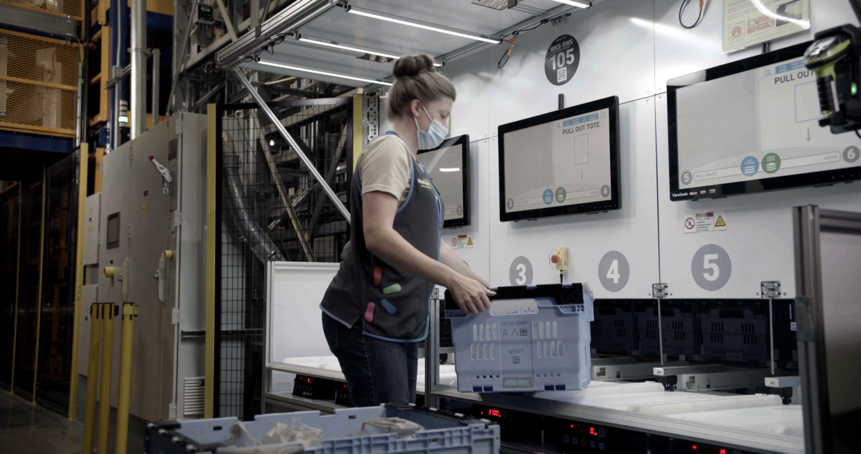 A Walmart associate packing an online order at a local fulfillment center.