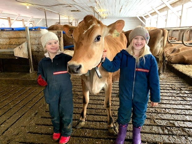 Heidi and Sophie Brosens are shown with Temperance the Jersey cow.