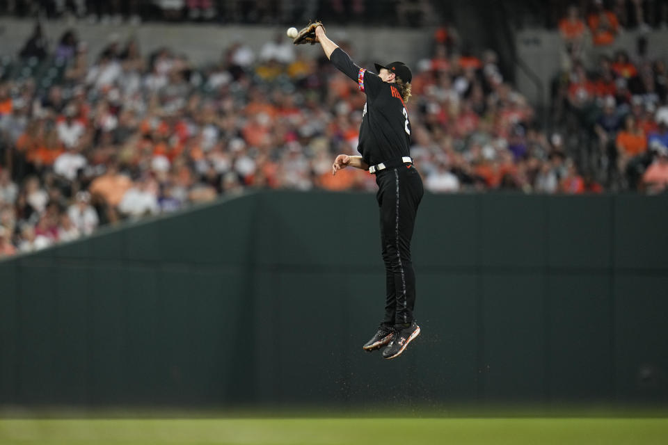 Baltimore Orioles third baseman Gunnar Henderson is unable to stop an RBI double by Colorado Rockies' Elias Diaz that scored Charlie Blackmon from first base during the third inning of a baseball game, Friday, Aug. 25, 2023, in Baltimore. (AP Photo/Julio Cortez)