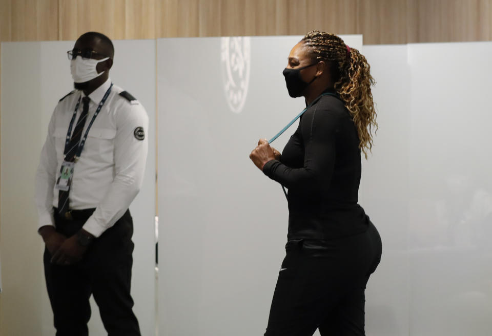 Serena Williams of the U.S., center, leaves after a video link press conference in which she announced her withdrawal from the tournament because of an Achilles injury prior to her second round match of the French Open tennis tournament at the Roland Garros stadium in Paris, France, Wednesday, Sept. 30, 2020. (AP Photo/Christophe Ena)