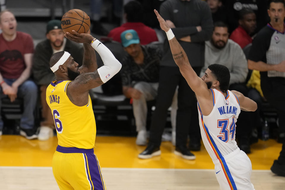 DELETES REFERENCE TO SHOT SETTING THE SCORING RECORD - Los Angeles Lakers forward LeBron James, left, shoots as Oklahoma City Thunder forward Kenrich Williams defends during the second half of an NBA basketball game Tuesday, Feb. 7, 2023, in Los Angeles. (AP Photo/Marcio Jose Sanchez)