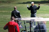 U.S. President Barack Obama warms up before playing a round of golf at Joint Base Andrews, Maryland April 5, 2014, in this picture shot through a window. REUTERS/Jonathan Ernst (UNITED STATES - Tags: POLITICS SPORT GOLF)