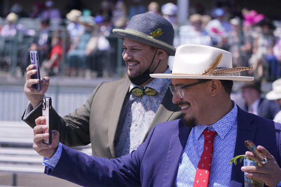 Men take photos of themselves before the 147th running of the Kentucky Derby at Churchill Downs, Saturday, May 1, 2021, in Louisville, Ky. (AP Photo/Michael Conroy)