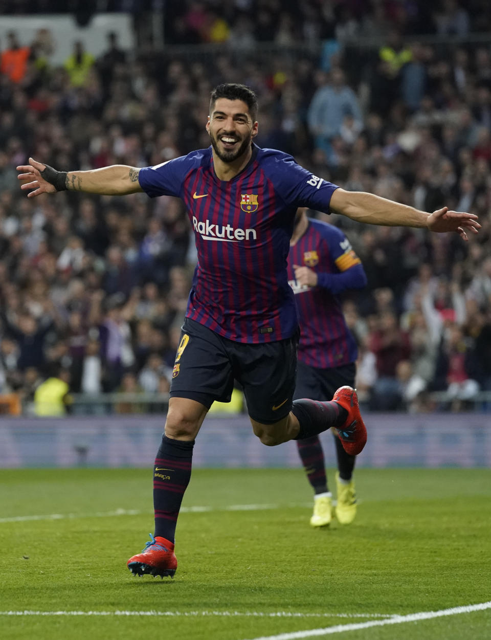 Barcelona forward Luis Suarez celebrates after Real defender Raphael Varane scores an own goal during the Copa del Rey semifinal second leg soccer match between Real Madrid and FC Barcelona at the Bernabeu stadium in Madrid, Spain, Wednesday Feb. 27, 2019. (AP Photo/Andrea Comas)