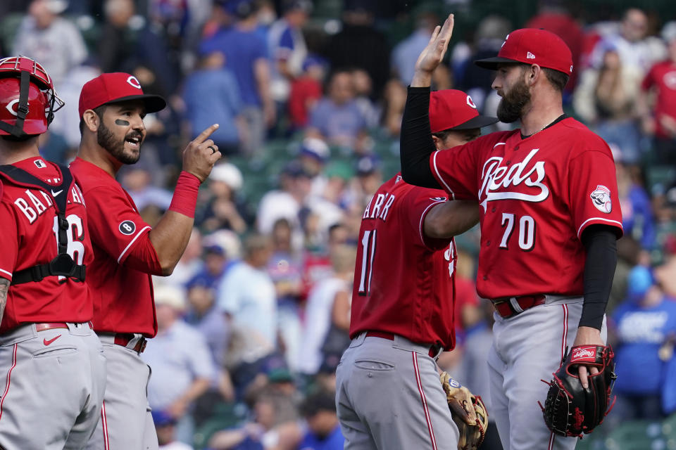 Cincinnati Reds relief pitcher Tejay Antone, right, celebrates with teammates Eugenio Suarez, second from left, and Kyle Farmer after they defeated the Chicago Cubs in a baseball game in Chicago, Sunday, May 30, 2021. (AP Photo/Nam Y. Huh)