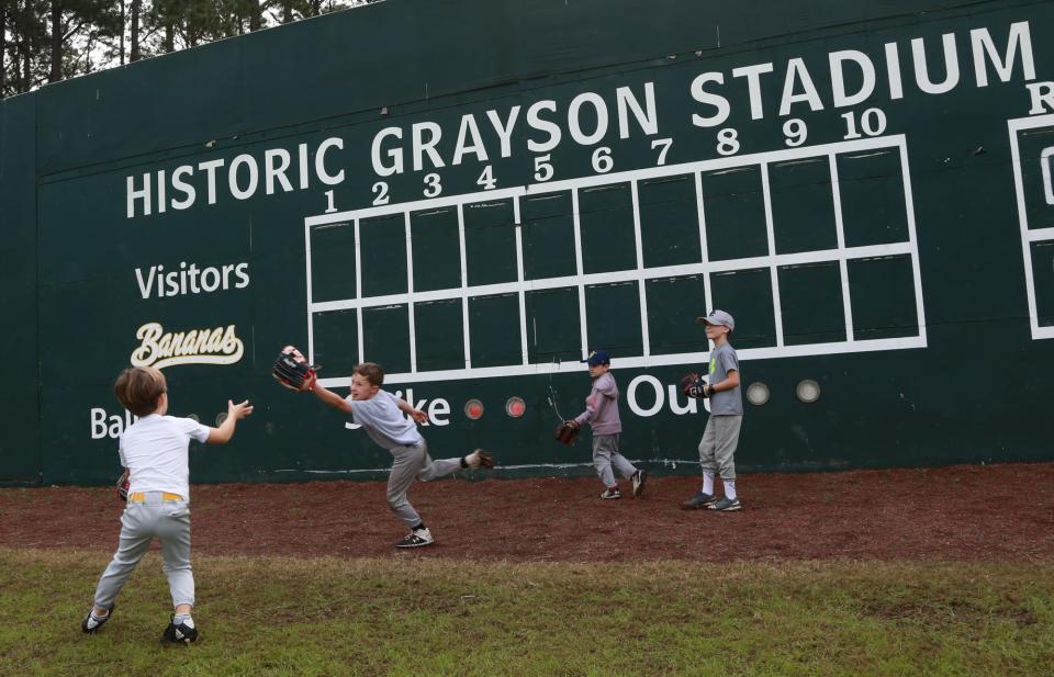 A camper catches a ball as it bounces off the outfield wall Tuesday during the Savannah Bananas winter youth baseball camp at Grayson Stadium.