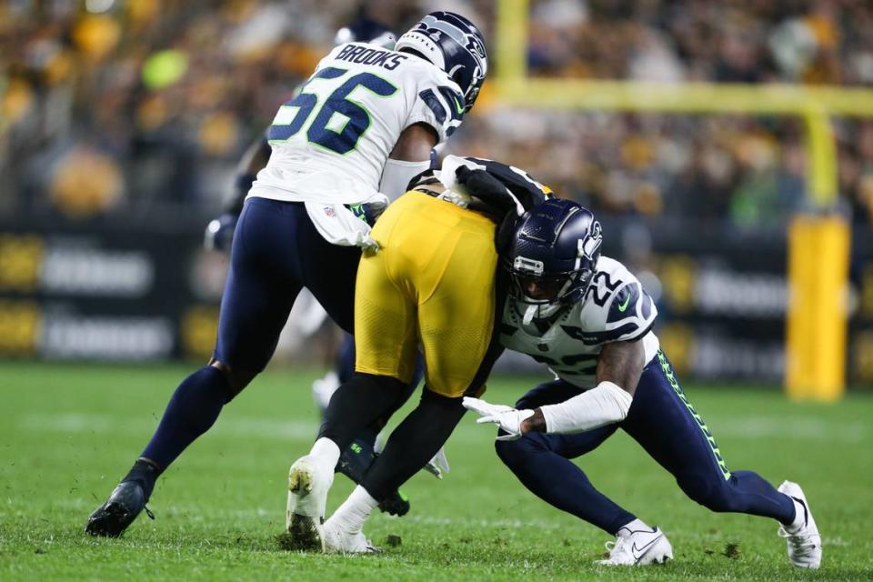 Seattle Seahawks cornerback Tre Brown (22) and Seattle Seahawks linebacker Jordyn Brooks (56) tackle Pittsburgh Steelers tight end Pat Freiermuth (88) during the first quarter. The Seattle Seahawks played the Pittsburgh Steelers at Heinz Field in Pittsburgh, Pa., on Sunday, Oct. 17, 2021.