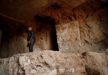 A man looks at artefacts and archaeological pieces in a tunnel network running under the Mosque of Prophet Jonah, Nabi Yunus in Arabic, in eastern Mosul, Iraq March 9, 2017. REUTERS/Suhaib Salem