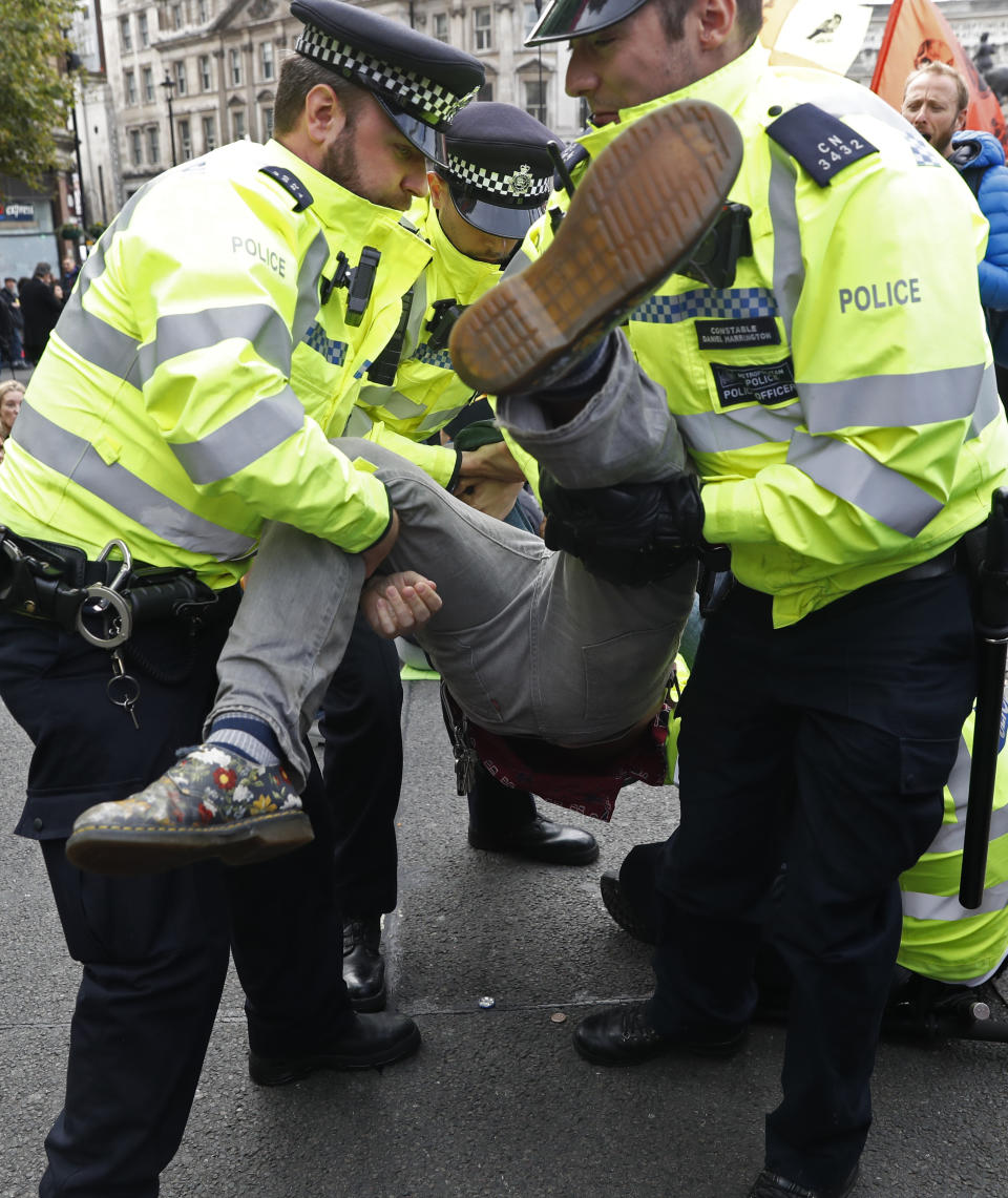 Police arrest a climate protestor after demonstrators blocked Trafalgar Square in central London Monday, Oct. 7, 2019. Extinction Rebellion movement blocked major roads in London, Berlin and Amsterdam on Monday at the beginning of what was billed as a wide-ranging series of protests demanding new climate policies. (AP Photo/Alastair Grant)