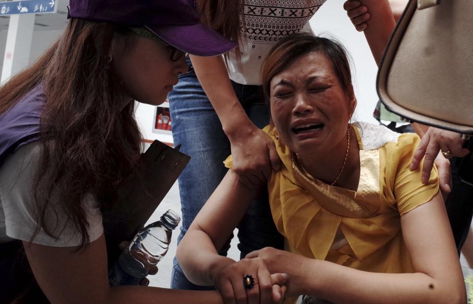 Volunteers comfort crying woman at a caring centre for relatives of victims of a factory explosion, in Kunshan