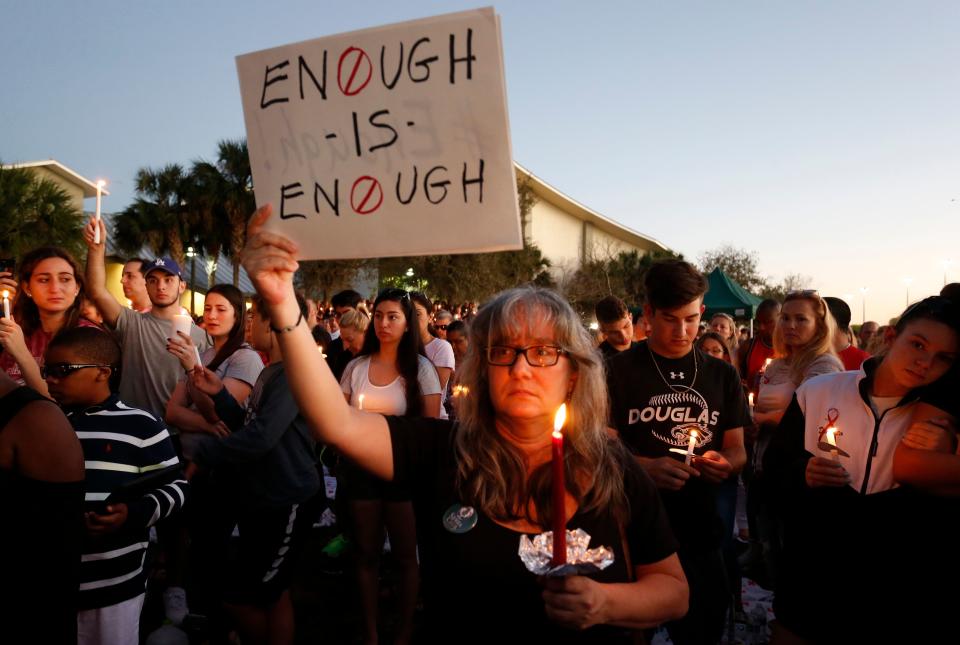 Mourners stand during a candlelight vigil for the victims of Marjory Stoneman Douglas High School shooting in Parkland, Florida on Feb. 15, 2018.